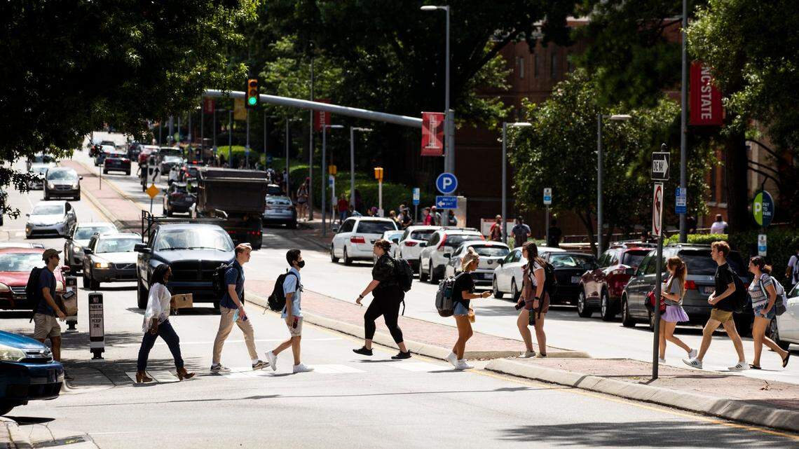 N.C. State students cross Hillsborough Street on the first day of classes for the fall semester, on Monday, Aug. 16, 2021, in Raleigh, N.C.