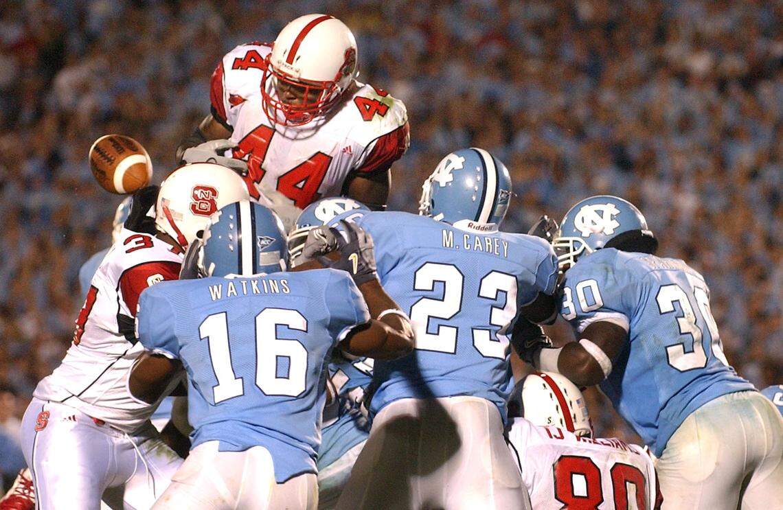 STATEUNC5.SP.100904.CEL--CHAPEL HILL,NC--10/09/04--UNC defenders Jacoby Watkins (16), Mahlon Carey (23) and Fred Sparkman (30) form a wall at the goal line as State’s T.A . McLendon fumbles the ball and State’s chances of a last second win Saturday October 9, 2004 in Kenan Stadium losing to the Tar Heels 30-24.STAFF PHOTO:CHUCK LIDDY