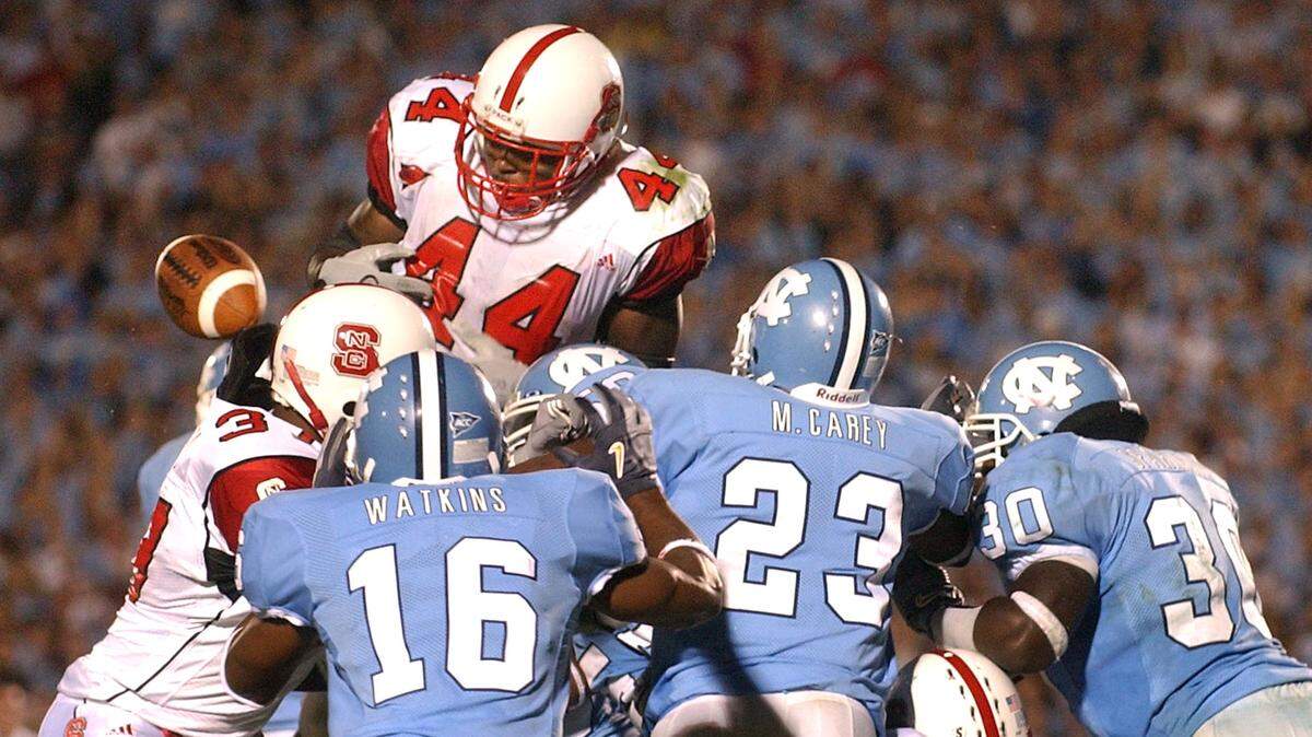 UNC defenders Jacoby Watkins (16), Mahlon Carey (23) and Fred Sparkman (30) form a wall at the goal line as State’s T.A . McLendon fumbles the ball and State’s chances of a last second win on Saturday October 9, 2004 in Kenan Stadium. N.C. State lost to the Tar Heels, 30-24.