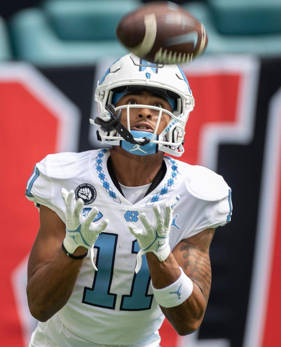 North Carolina’s Josh Downs (11) focuses on making a catch as the Tar Heels warm up for their game against Miami on Saturday, October 8, 2022 at Hard Rock Stadium in Miami Gardens, Florida.