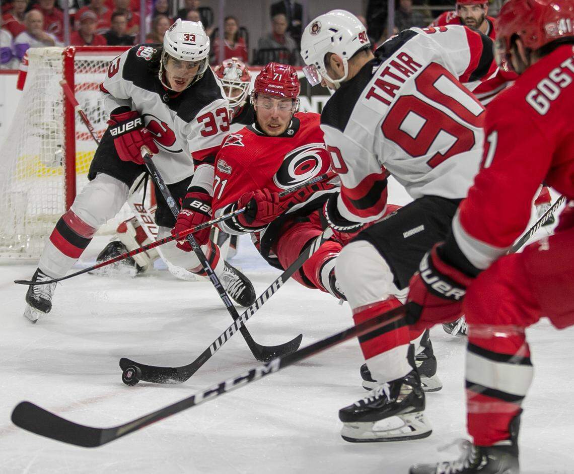 The New Jersey Devils Ryan Graves (33) and Tomas Tatar (90) clear the puck preventing the Carolina Hurricanes Jesper Fast (71) from a rebound attempt on goalie Akira Schmid (40) in the first period during Game 2 of their second round Stanley Cup playoff series on Friday, May 5, 2023 at PNC Arena in Raleigh, N.C.