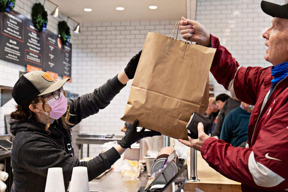 A customer picks up a to-go order at Prime Barbecue in Knightdale, NC, on Wednesday, Dec. 8, 2021.