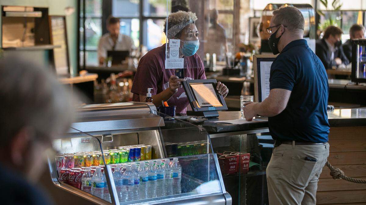 Regina Wagner takes an order from a customer at Locals Oyster Bar in the Transfer Co.Food Hall on Tuesday, October 26, 2021 in Raleigh, N.C. Wagner was laid off from another job in November 2020, was unemployed for four months, before finding work at Locals in February.