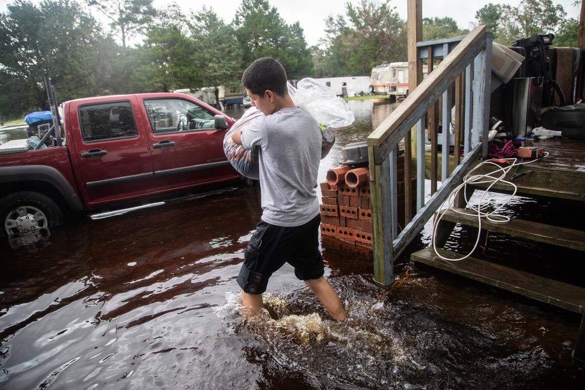 Dorian Gallegos, 15, helps his family move  out of a flooded home on Will Baker Road in Kinston Sunday, Sept. 16, 2018 following the aftermath of Hurricane Florence. Flood levels are expected to rise in parts of Kinston.