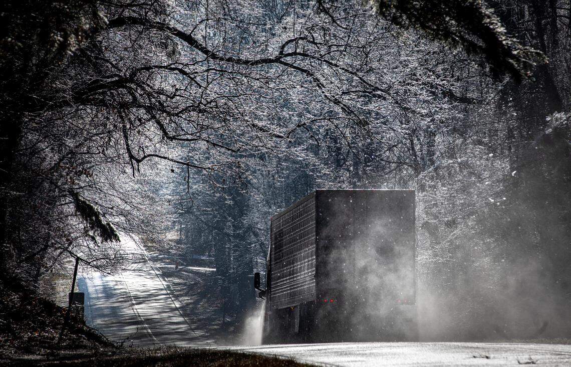 A truck heads down a hill through a tunnel of ice-coated trees on Highway 98 near the Wake-Nash County line, Saturday, Jan. 11, 2025.