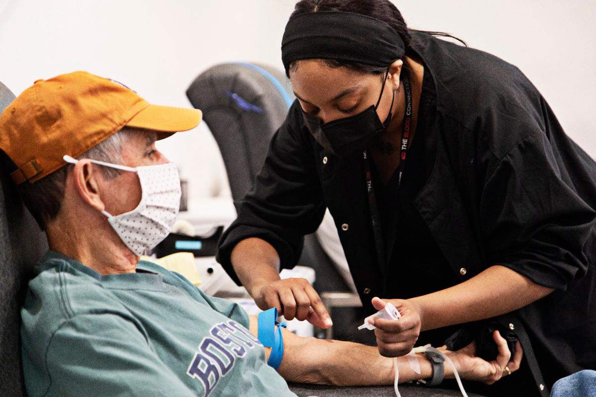 Phlebotomist Mya Johnson with The Blood Connection in Raleigh, right, prepares Dave Kellys arm for a donation on Thursday morning, Jan. 13, 2022. Kelly has regularly given blood for the last six or seven years. He says, its just a way to help other people and its easy to do.
