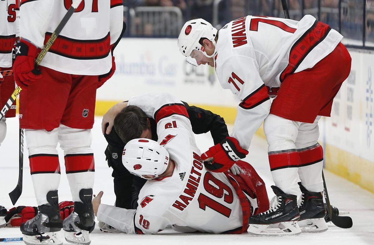 Carolina Hurricanes’ head athletic trainer Doug Bennett attends to Dougie Hamilton after Hamilton was injured in the second period of an NHL hockey game against the Columbus Blue Jackets, Thursday, Jan. 16, 2020, in Columbus, Ohio.