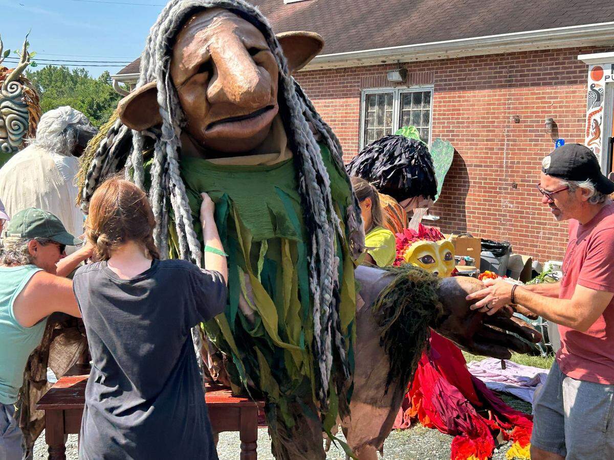 Volunteers at Paperhand Puppet Intervention dry out a large puppet damaged in Haw River flooding in Saxapahaw.