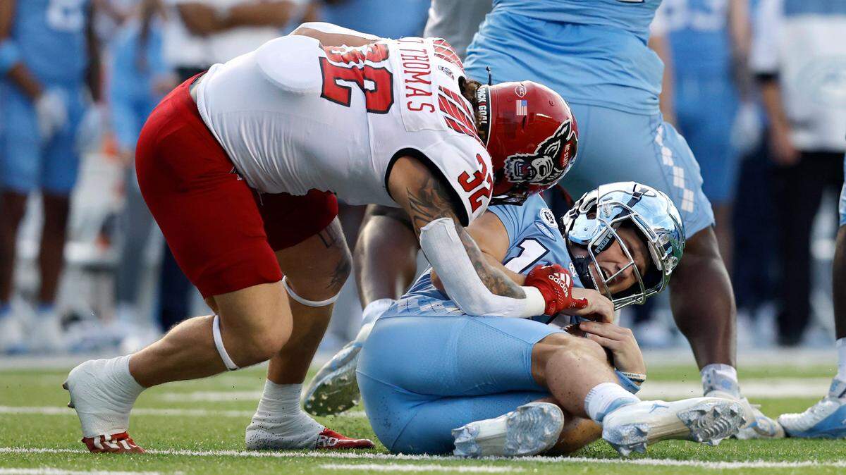 N.C. State linebacker Drake Thomas (32) sacks North Carolina quarterback Drake Maye (10) during the first half of N.C. State’s game against UNC at Kenan Stadium in Chapel Hill, N.C., Friday, Nov. 25, 2022.