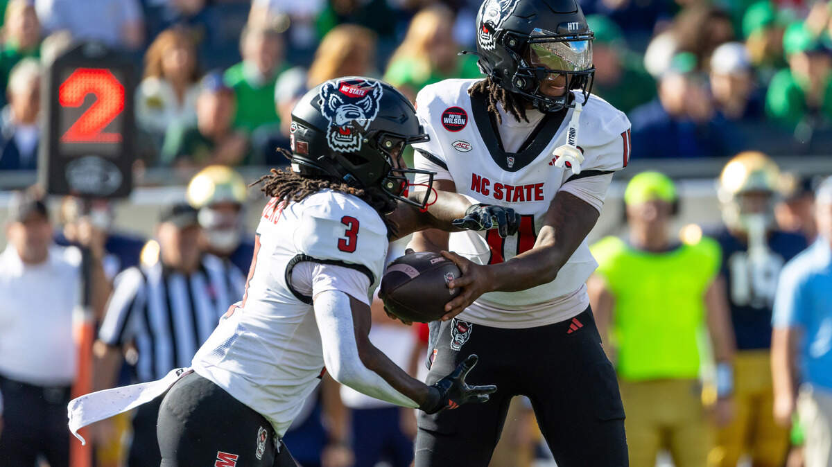 NC State Wolfpack quarterback CJ Bailey (11) hands off to running back Hollywood Smothers (3) during the first half at Notre Dame Stadium.