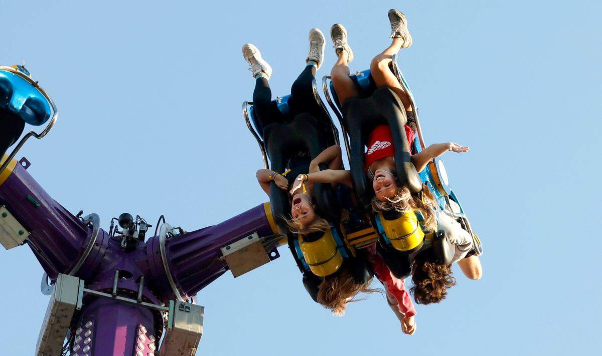 Addie Lowder, left, and her sister, Haynes, ride Khaos at the N.C. State Fair in Raleigh, N.C., Thursday, Oct. 12, 2023.
