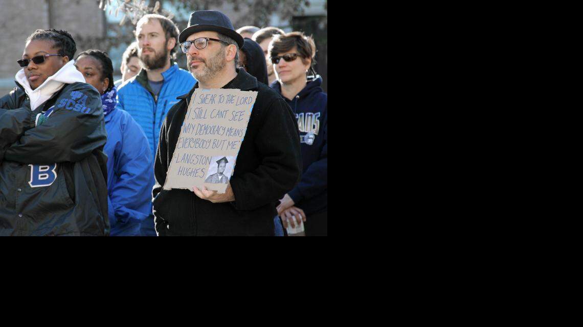 Orange County Commissioner Mark Dorosin, a civil rights attorney, holds a sign bearing a quote from poet and activist Langston Hughes on Monday, Jan. 19, 2015. More than 100 people attended the Chapel Hill-Carrboro NAACP’s annual Martin Luther King Jr. rally on Peace and Justice Plaza before marching down Franklin Street to First Baptist Church for a community service and more speakers.