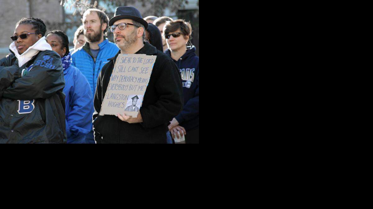 Orange County Commissioner Mark Dorosin, a civil rights attorney, holds a sign bearing a quote from poet and activist Langston Hughes on Monday, Jan. 19, 2015. More than 100 people attended the Chapel Hill-Carrboro NAACP’s annual Martin Luther King Jr. rally on Peace and Justice Plaza before marching down Franklin Street to First Baptist Church for a community service and more speakers.