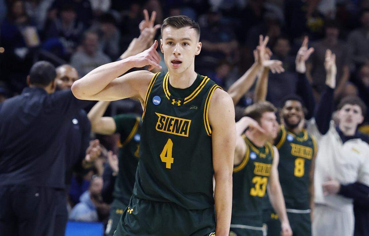 Siena's Gavin Doty (4) celebrates hitting a three-pointer during the first half of Duke’s game against Siena in the first round of the NCAA Men’s Basketball Tournament at Bon Secours Wellness Arena in Greenville Thursday. Doty finished with 21 points.