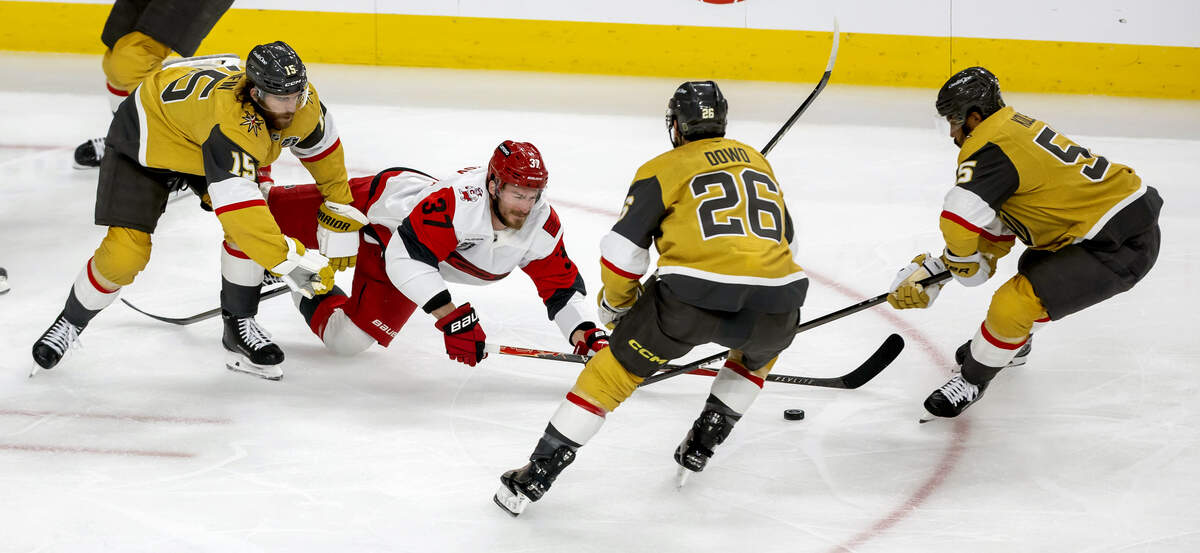 Vegas defenseman Noah Hanifin (15) checks Carolina Hurricanes right wing Andrei Svechnikov (37) to the ice in the first period, as teammates Noah Hanifin (15) and Keegan Kolesar (55) take control of the puck in the first period in Game 3 of the Stanley Cup Final, on Saturday, June 6, 2026 at T-Mobile Arena in Las Vegas, NV.