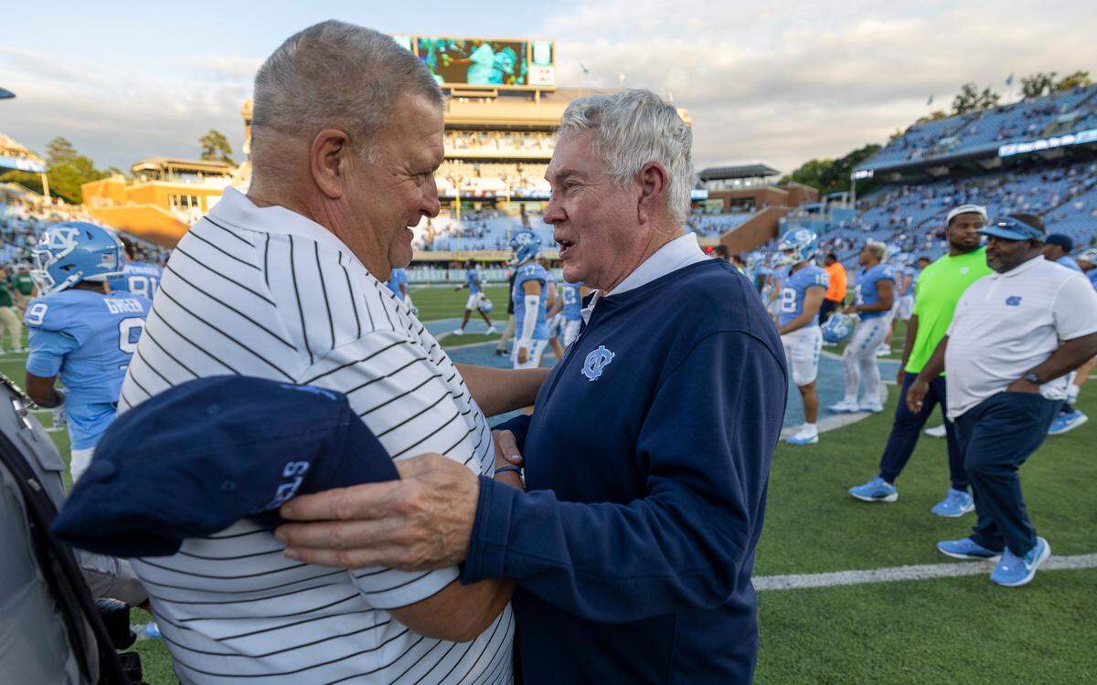 Charlotte head coach Biff Poggi congratulates North Carolina coach Mack Brown following the Tar Heels’ 38-20 victory on Saturday, September 7, 2024 at Kenan Stadium in Chapel Hill, N.C.