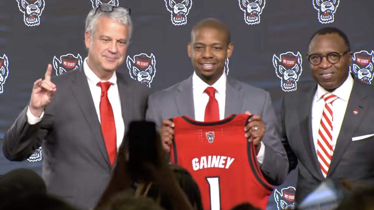 New N.C. State basketball coach Justin Gainey is introduced at a press conference Wednesday. At left is Athletic Director Boo Corrigan and Chancellor Kevin Howell.