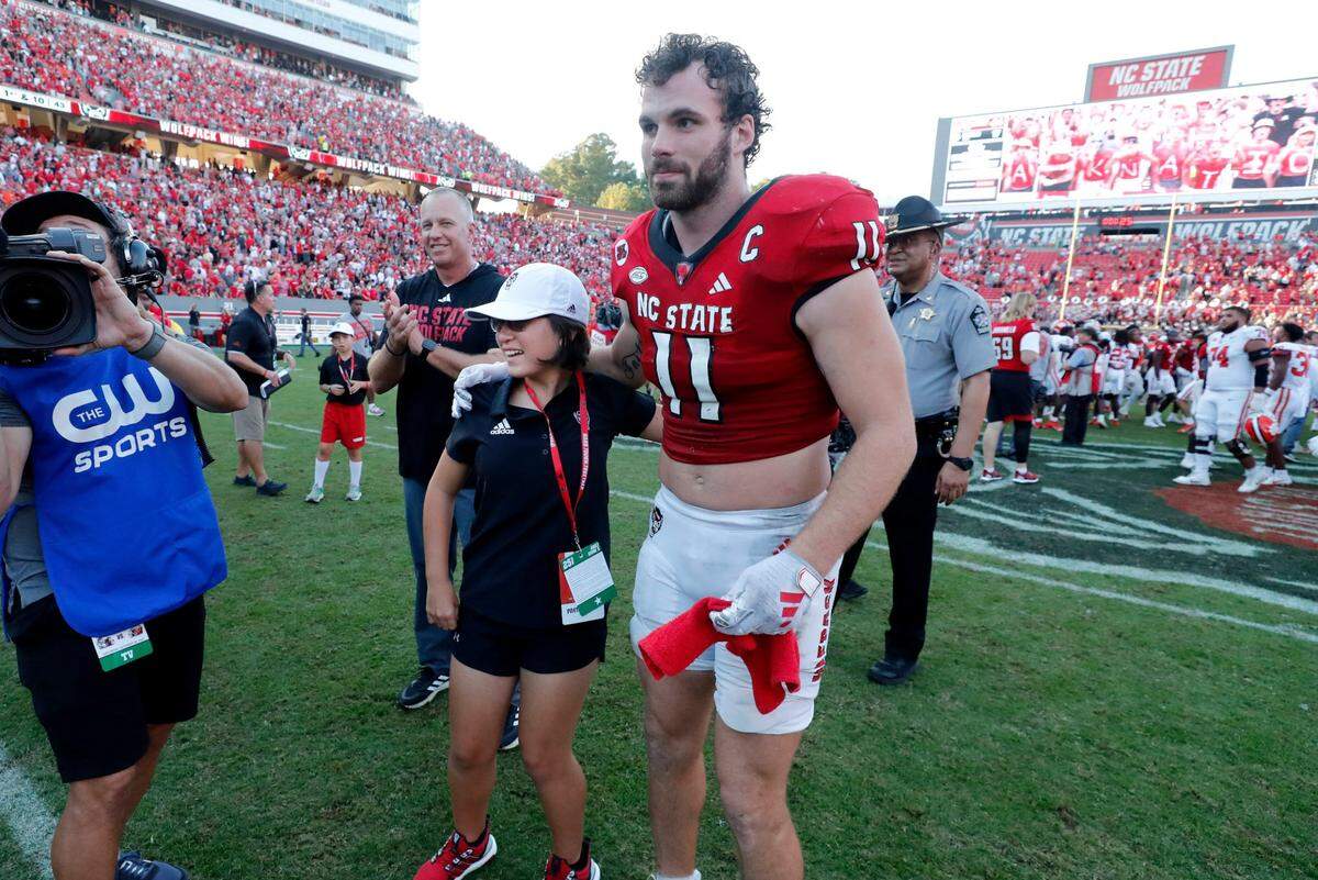 N.C. State linebacker Payton Wilson (11) gives Payton Gibbs a hug after N.C. State’s 24-17 victory over Clemson at Carter-Finley Stadium in Raleigh, N.C., Saturday, Oct. 28, 2023.