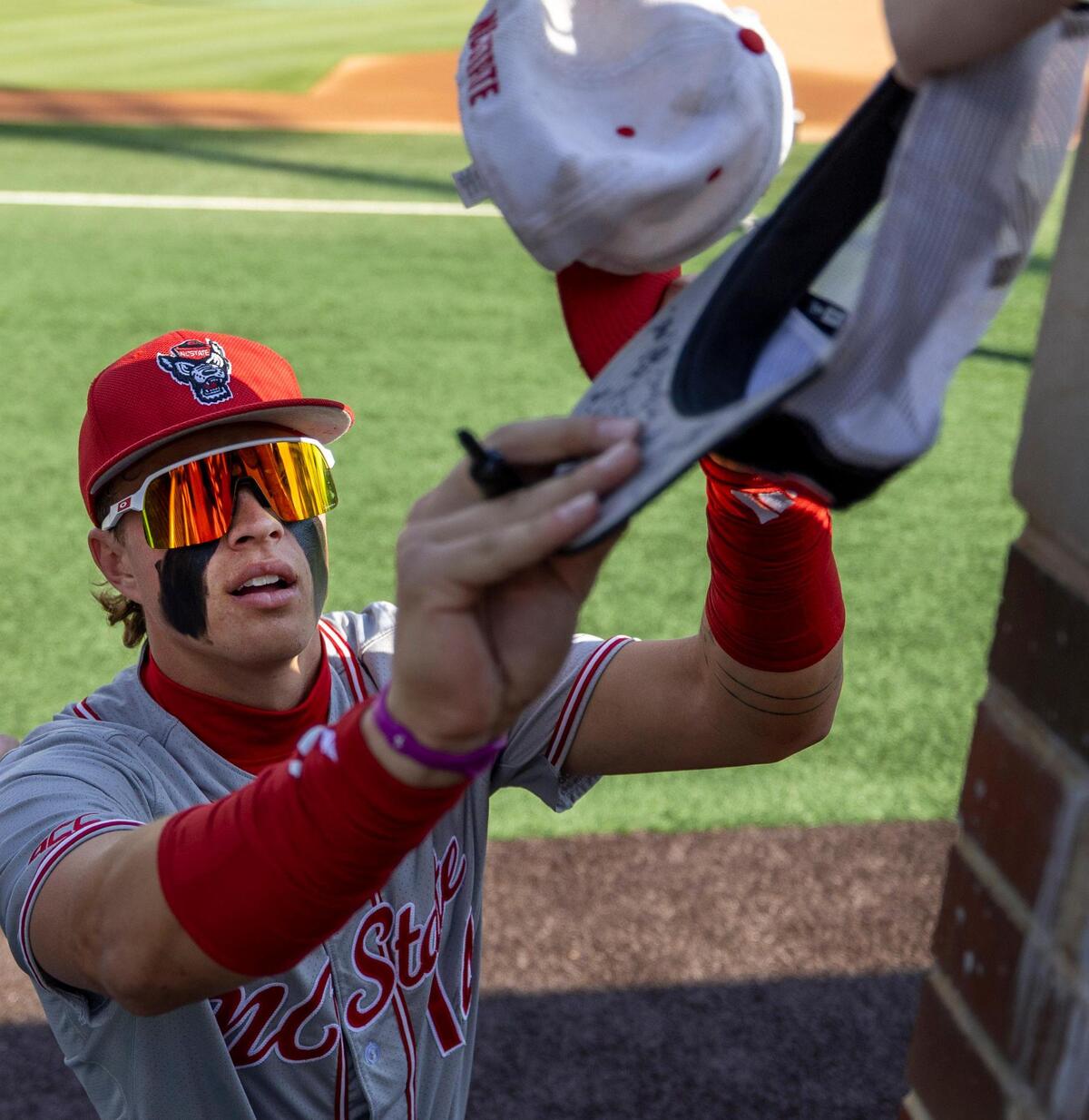 N.C. State outfielder Ty Head (14) autographs hats for fans prior to the Wolfpack’s game against the North Carolina Tar Heels on Friday, May 9, 2025 at Boshamer Stadium in Chapel Hill, N.C.
