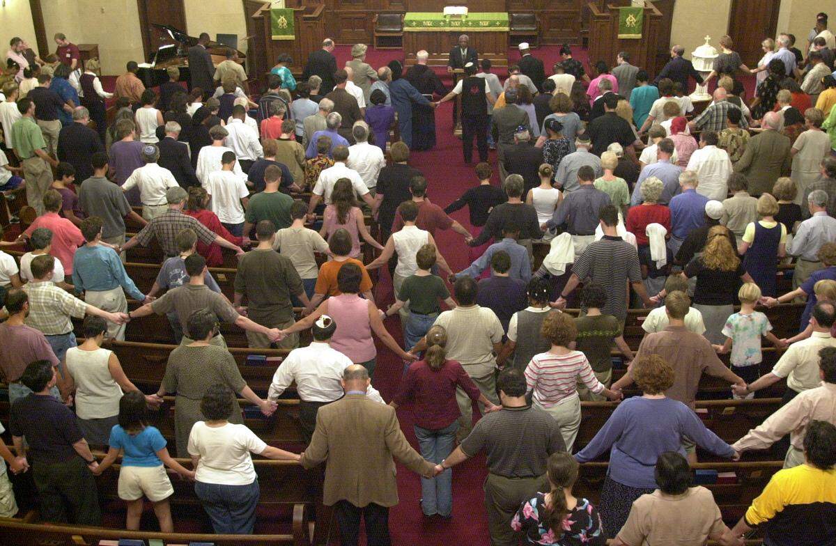 Bishop Elroy Lewis from the Fisher Memorial United Holy Church leads a gathering from all different faiths in a closing prayer at the First Presbyterian Church in Durham Tuesday evening, Sept. 11, 2001.