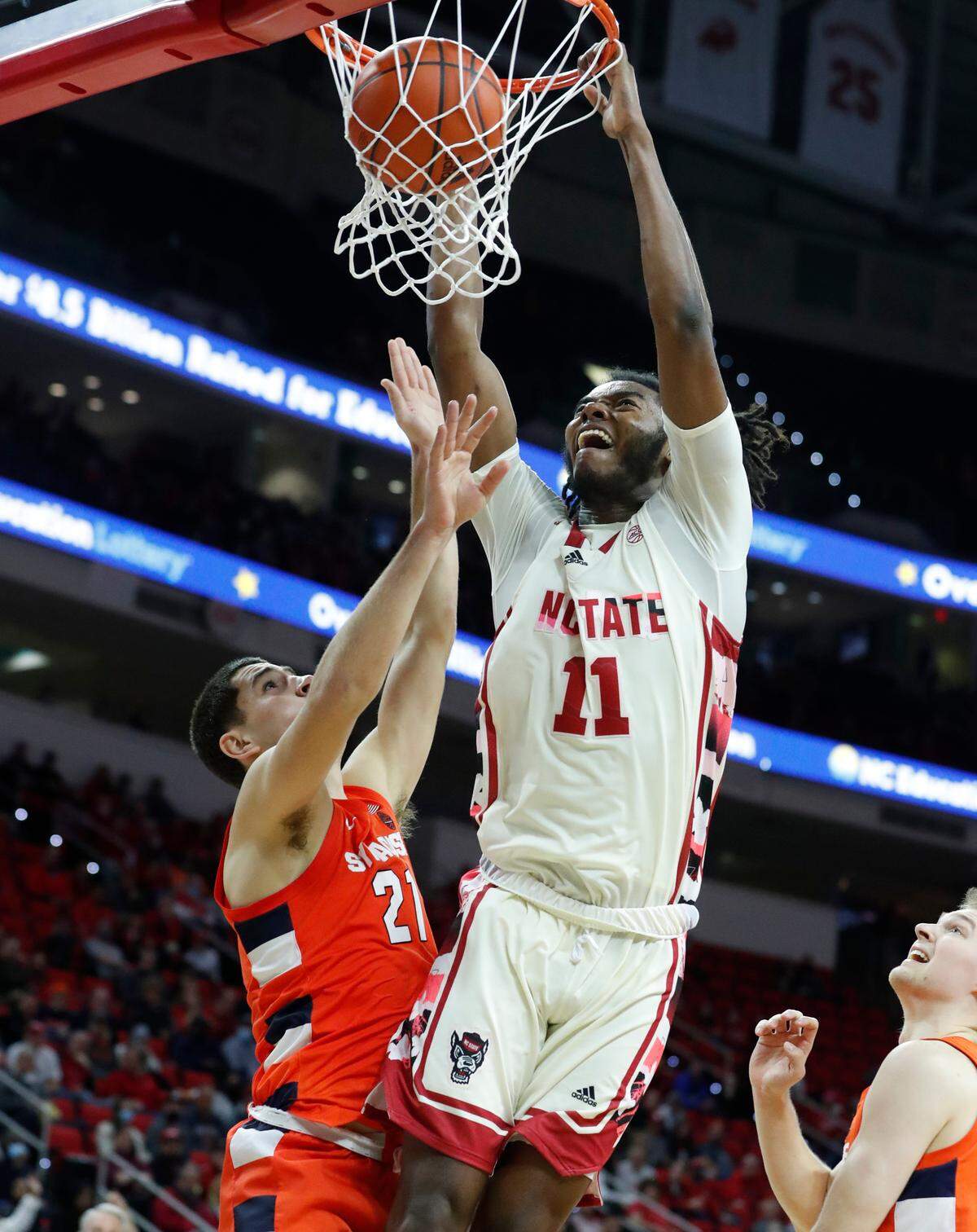 N.C. State’s Jaylon Gibson (11) slams in two as Syracuse’s Cole Swider (21) defends during the second half of Syracuse’s 89-82 victory over N.C. State at PNC Arena in Raleigh, N.C., Wednesday, Feb. 2, 2022.