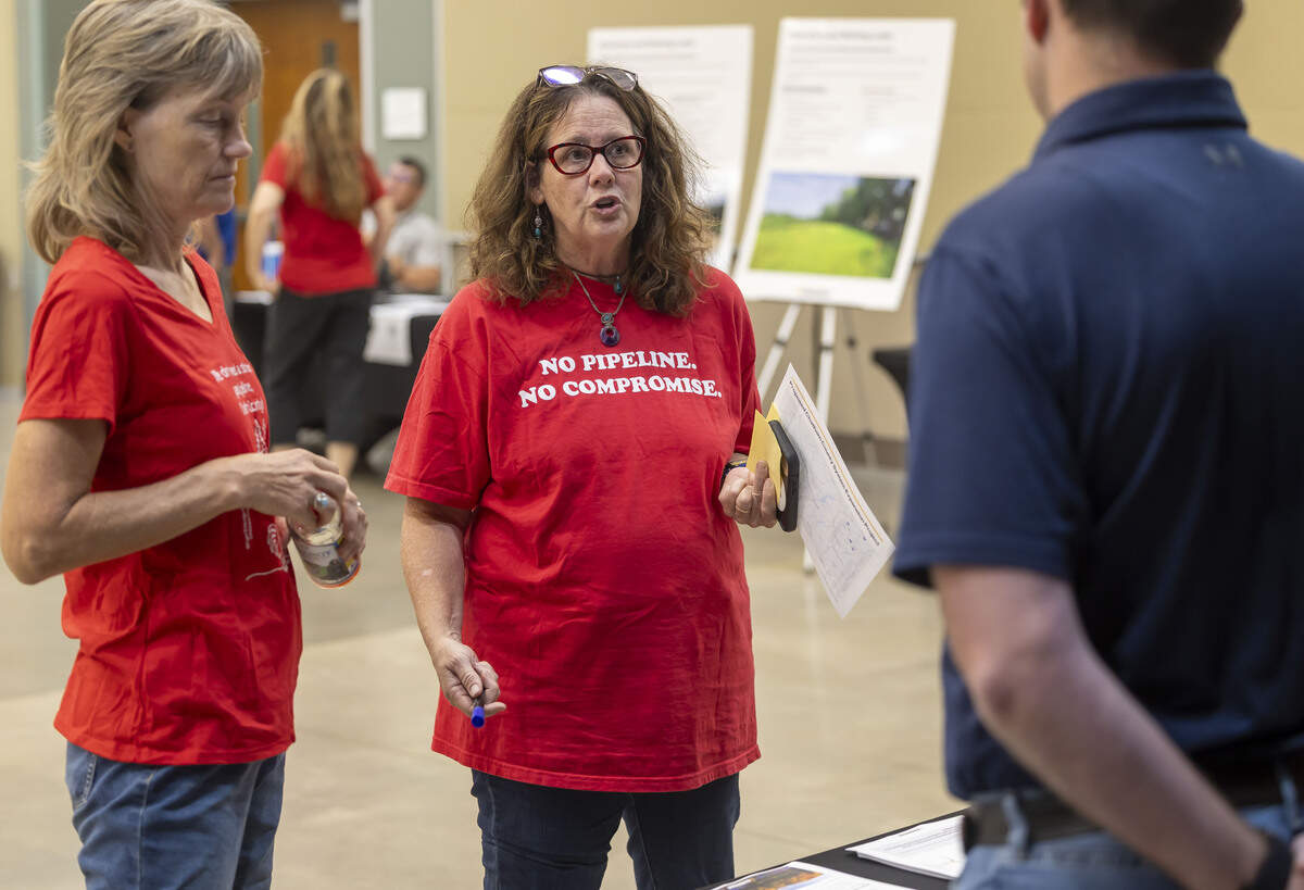 Chatham County resident Whitney Schmidt, talks with a representative from Enbridge during an information session regarding a proposed 28-mile natural gas pipeline, on Tuesday, July 28, 2026, at the Chatham County Agriculture & Conference Center in Pittsboro, N.C.