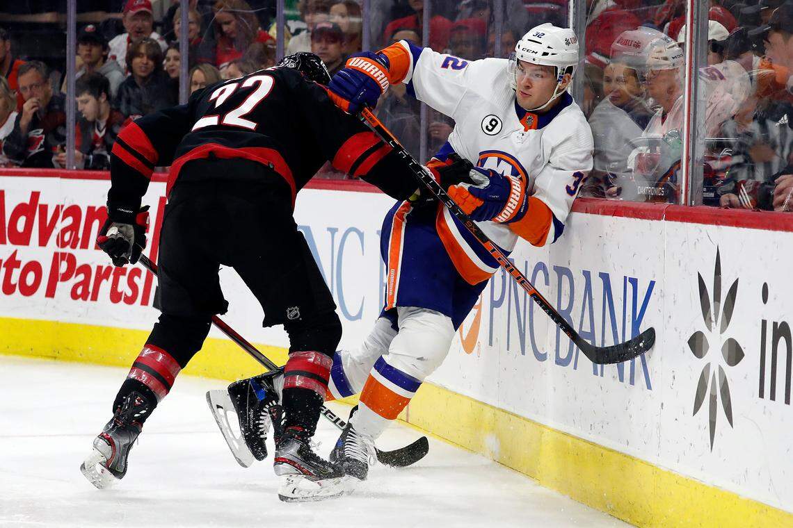 Carolina Hurricanes’ Brett Pesce (22) collides with New York Islanders’ Ross Johnston (32) during the first period of an NHL hockey game in Raleigh, N.C., Friday, April 8, 2022. (AP Photo/Karl B DeBlaker)