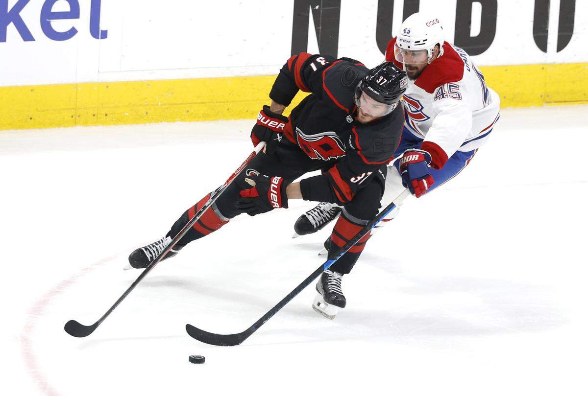 Carolina's Andrei Svechnikov (37) works the puck past Montréal's Alexandre Carrier (45) in the second period of the Hurricanes’ game against the Canadiens in game two of the Eastern Conference Finals at the Lenovo Center in Raleigh, N.C., Saturday, May 23, 2026.
