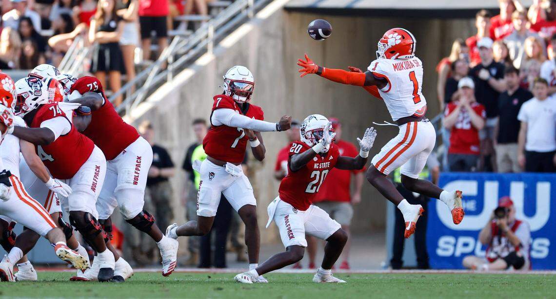 N.C. State quarterback MJ Morris (7) passes past Clemson safety Andrew Mukuba (1) during the second half of N.C. State’s 24-17 victory over Clemson at Carter-Finley Stadium in Raleigh, N.C., Saturday, Oct. 28, 2023.