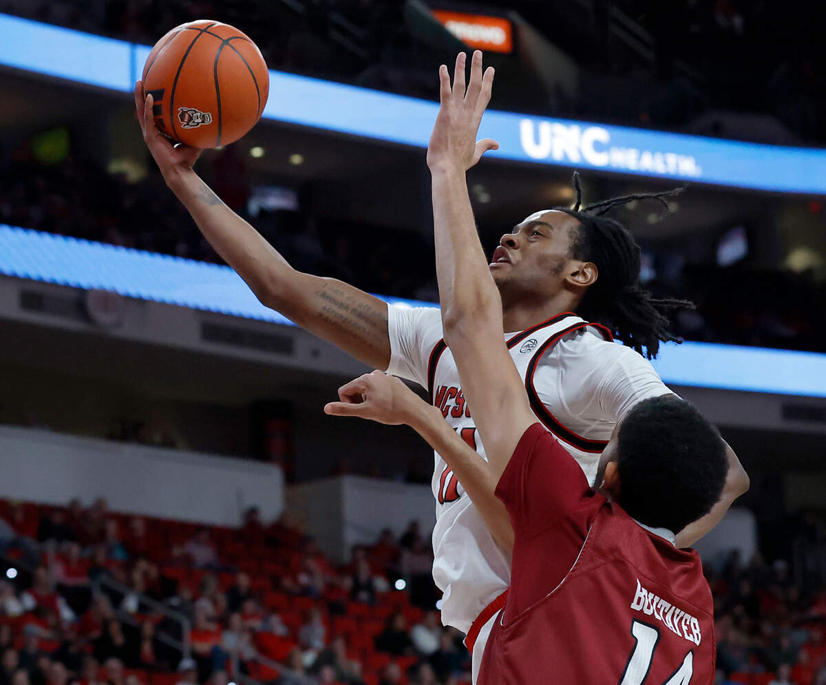 N.C. State’s Dennis Parker Jr. drives to the basket past Rider’s Alaaeddine Boutayeb during the first half of the Wolfpack’s 89-63 win on Sunday, Dec. 22, 2024, at Lenovo Center in Raleigh, N.C.