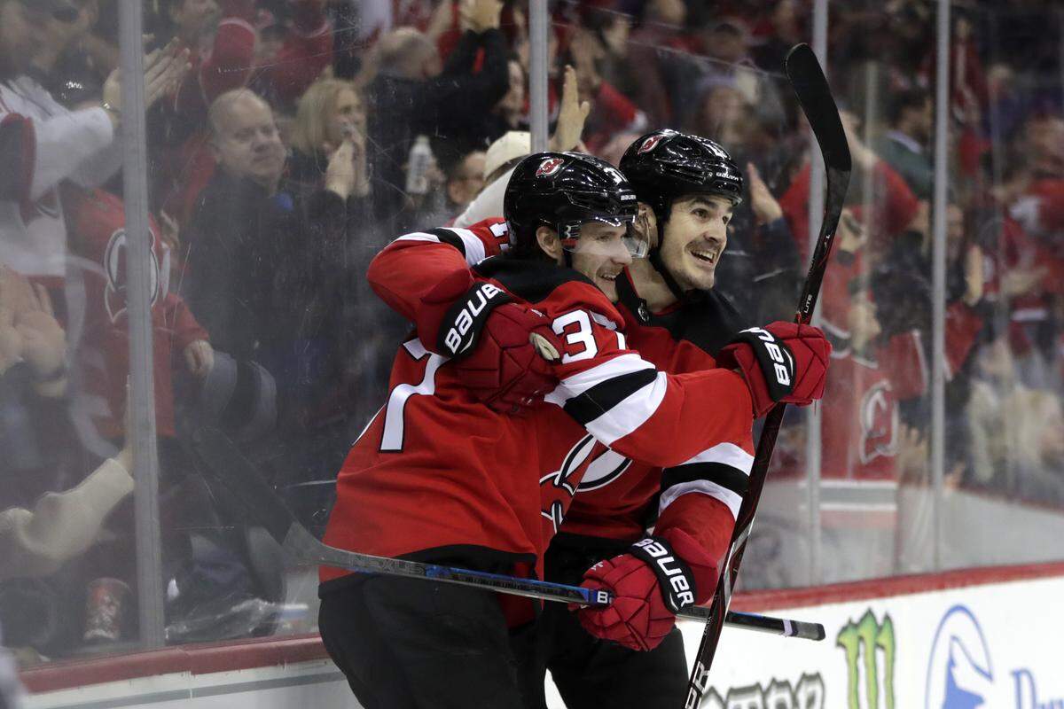 New Jersey Devils center Pavel Zacha, left, of the Czech Republic, celebrates his second period goal with Brian Boyle during an NHL hockey game against the Carolina Hurricanes, Saturday, Dec. 29, 2018, in Newark, N.J. (AP Photo/Julio Cortez)