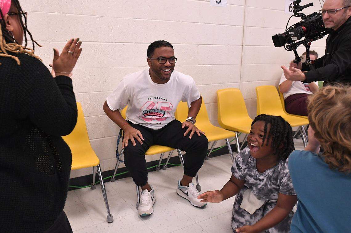 Fourth-grade teacher Shane Henderson sits at the front of the stage at Pittsboro Elementary School after learning he’s received a Milken Educator Award Wednesday.