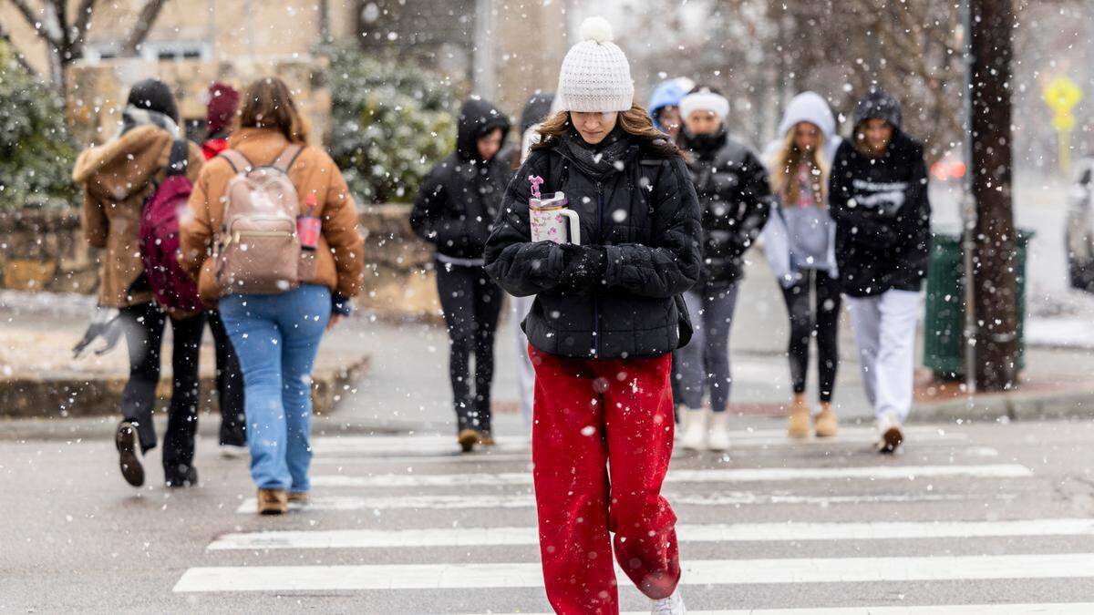 Pedestrians brave the freezing temperature as snow begins to fall at UNC-Chapel Hill on Wednesday, Feb. 19, 2024.