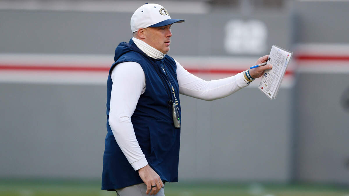 Georgia Tech head coach Geoff Collins watches his team warm up before N.C. State’s game against Georgia Tech at Carter-Finley Stadium in Raleigh, N.C., Saturday, Dec. 5, 2020.