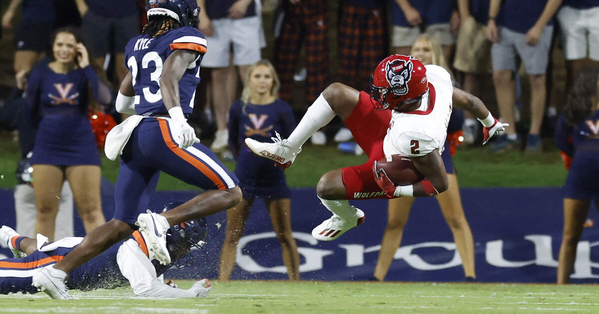 N.C. State running back Michael Allen (2) is tripped up by Virginia cornerback Malcolm Greene (8) during the second half of N.C. State’s 24-21 victory over Virginia at Scott Stadium in Charlottesville, Va., Friday, Sept. 22, 2023.