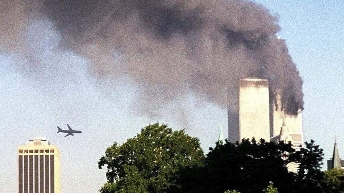 A plane approaches New York’s World Trade Center moments before it struck the tower at left, as seen from downtown Brooklyn, Tuesday, Sept. 11, 2001.
