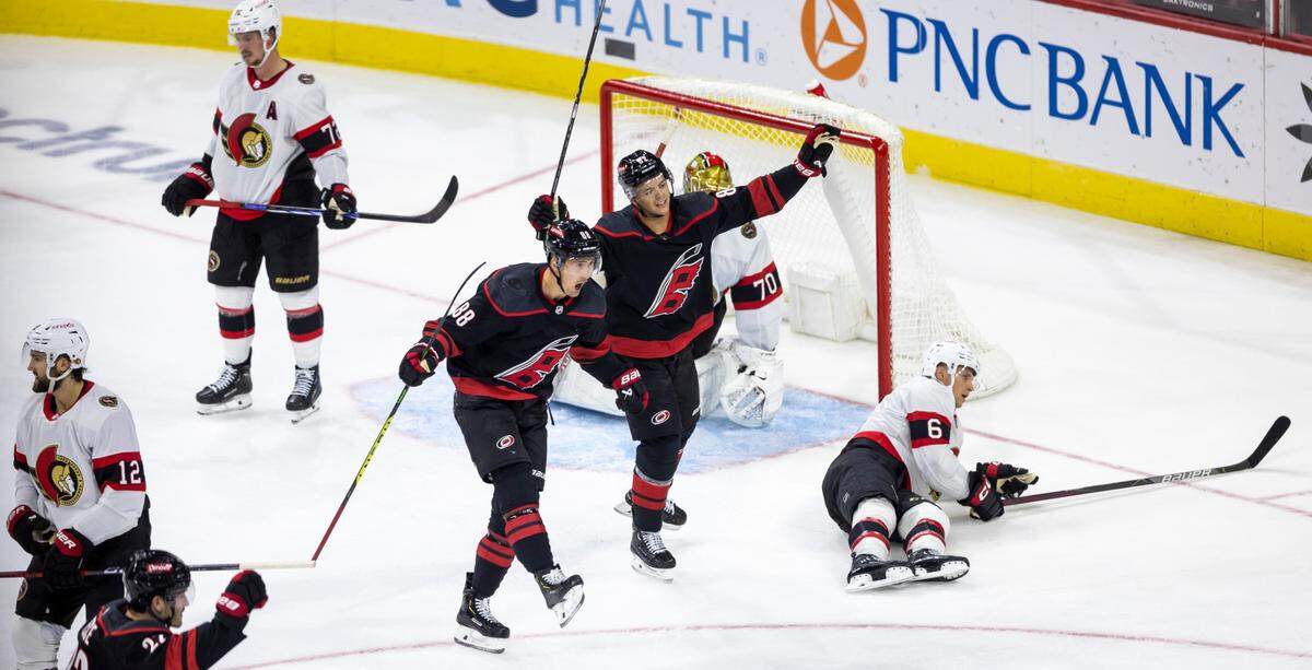 The Carolina Hurricanes Jesper Fast (71) and Jesperi Kotkaniemi (82) react after a goal by teammate Teuvo Teravainen (86) to give the Hurricanes a 2-1 lead in the second period on Wednesday, October 11, 2023 at PNC Arena, in Raleigh N.C.