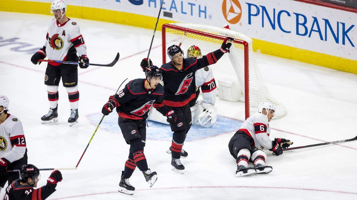 The Carolina Hurricanes Jesper Fast (71) and Jesperi Kotkaniemi (82) react after a goal by teammate Teuvo Teravainen (86) to give the Hurricanes a 2-1 lead in the second period on Wednesday, October 11, 2023 at PNC Arena, in Raleigh N.C.