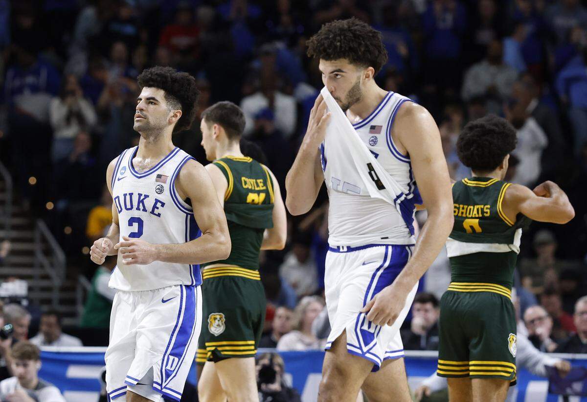 Duke’s Cayden Boozer (2) and Cameron Boozer (12) walk back to the bench after Duke’s 71-65 victory over Siena in the first round of the NCAA Men’s Basketball Tournament at  Bon Secours Wellness Arena in Greenville, S.C., Thursday, March 19, 2026.