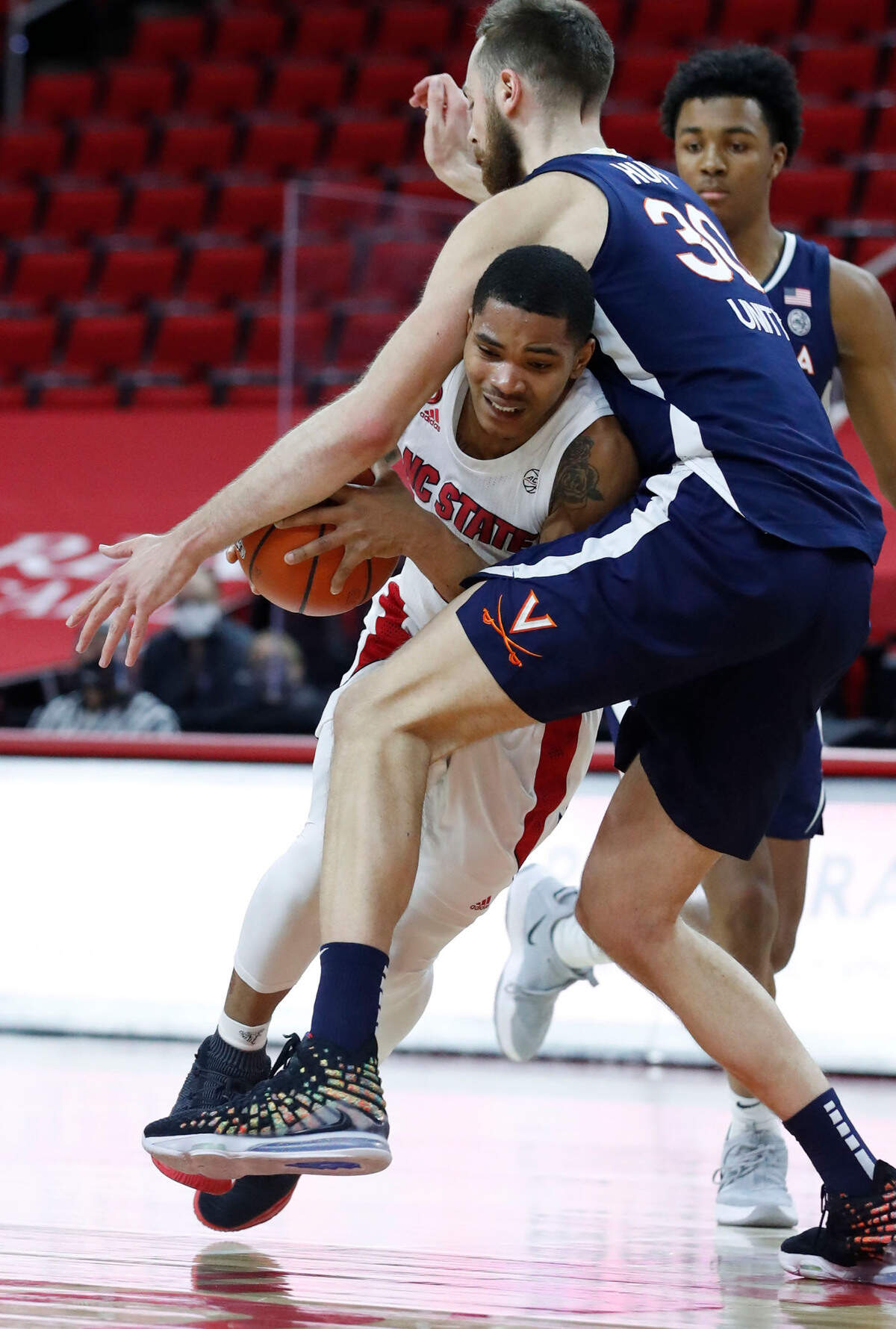 N.C. State’s Shakeel Moore (2) tries to get by Virginia’s Jay Huff (30) during the second half of Virginia’s 64-57 victory over N.C. State at PNC Arena in Raleigh, N.C., Wednesday, February 3, 2021.