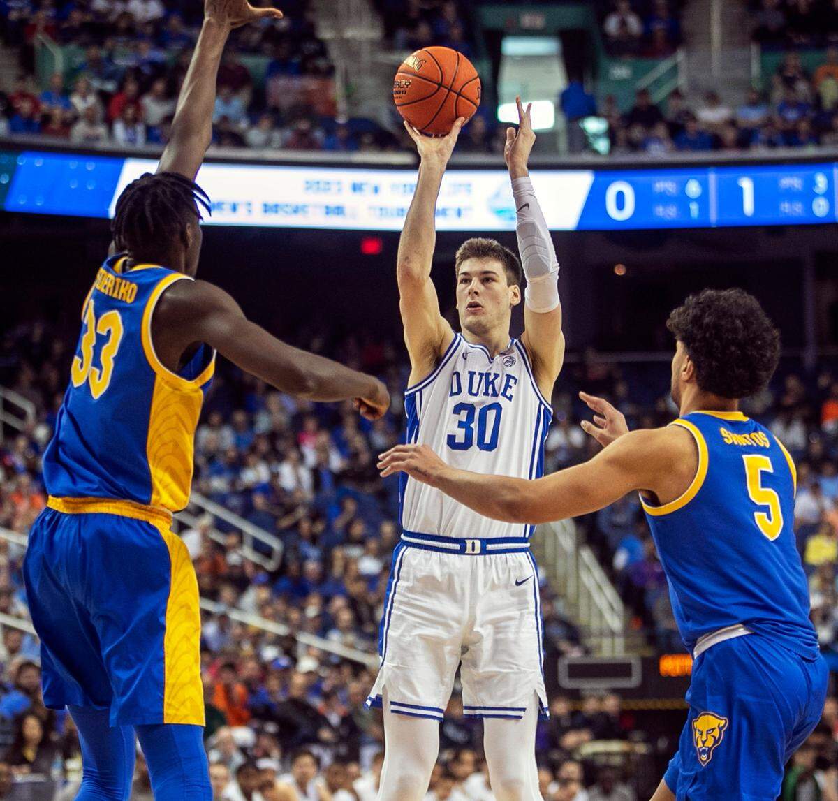 Duke’s Kyle Filipowski (30 sinks three point basket in the first half against Pittsburgh’s Federiko Federiko (33) and Nate Santos (5) to give the Blue Devils’ a 15 point lead during the third round of the ACC Tournament on Thursday, March 9, 2023 at the Greensboro Coliseum in Greensboro, N.C.