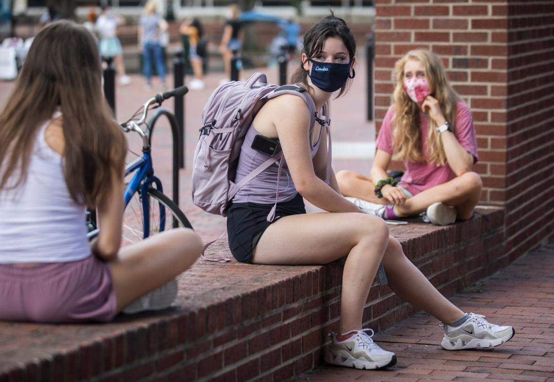 First year students Susan Davis, middle, Amelia Loeffler, right, and Eliza Jackson-Wald, left, hang out while socially distanced near Davis Library on UNC-Chapel Hill’s campus on Thursday, Aug. 6, 2020.