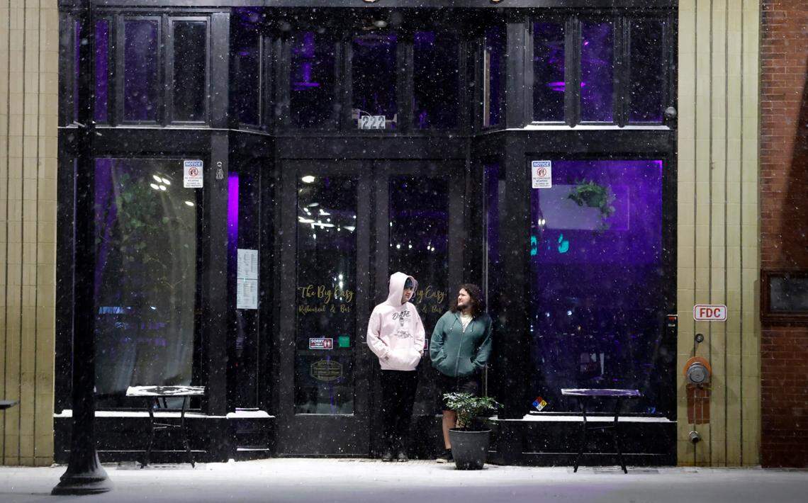 Arijan Wellard, right, and Cameron Betz, wait for their Uber outside The Big Easy as snow falls in downtown Raleigh, N.C., Tuesday evening, Jan. 21, 2025.