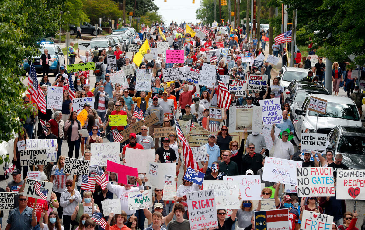 Protesters march down Lane Street during the ReOpen NC protest in downtown Raleigh, N.C. Tuesday, April 21, 2020.