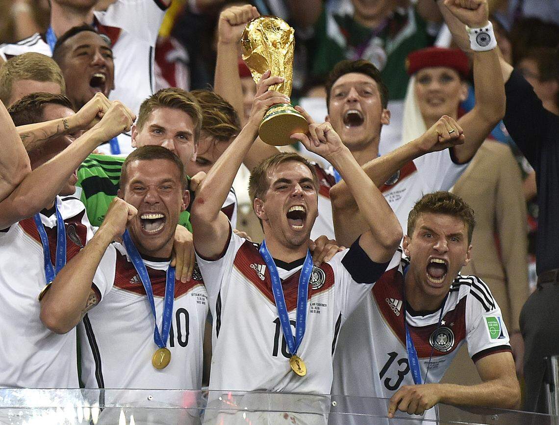 Germany's Philipp Lahm (16) raises the trophy after the World Cup final soccer match between Germany and Argentina in Rio de Janeiro, Brazil, on July 13, 2014. Germany hopes to lift the trophy in 2018 and become the first repeat champion in more than a half-century in the worldwide soccer tournament that is contested every four years.