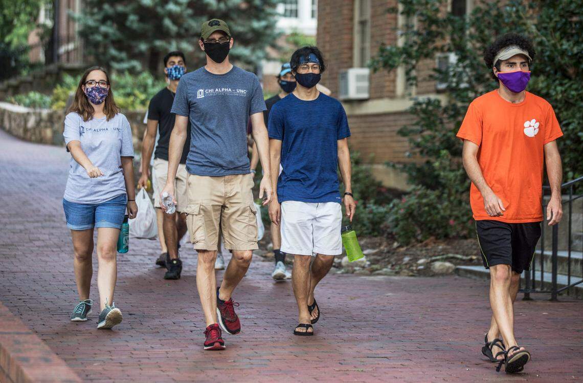 A masked group of people walk through Polk Place on UNC-Chapel Hill’s campus on Thursday, Aug. 6, 2020.