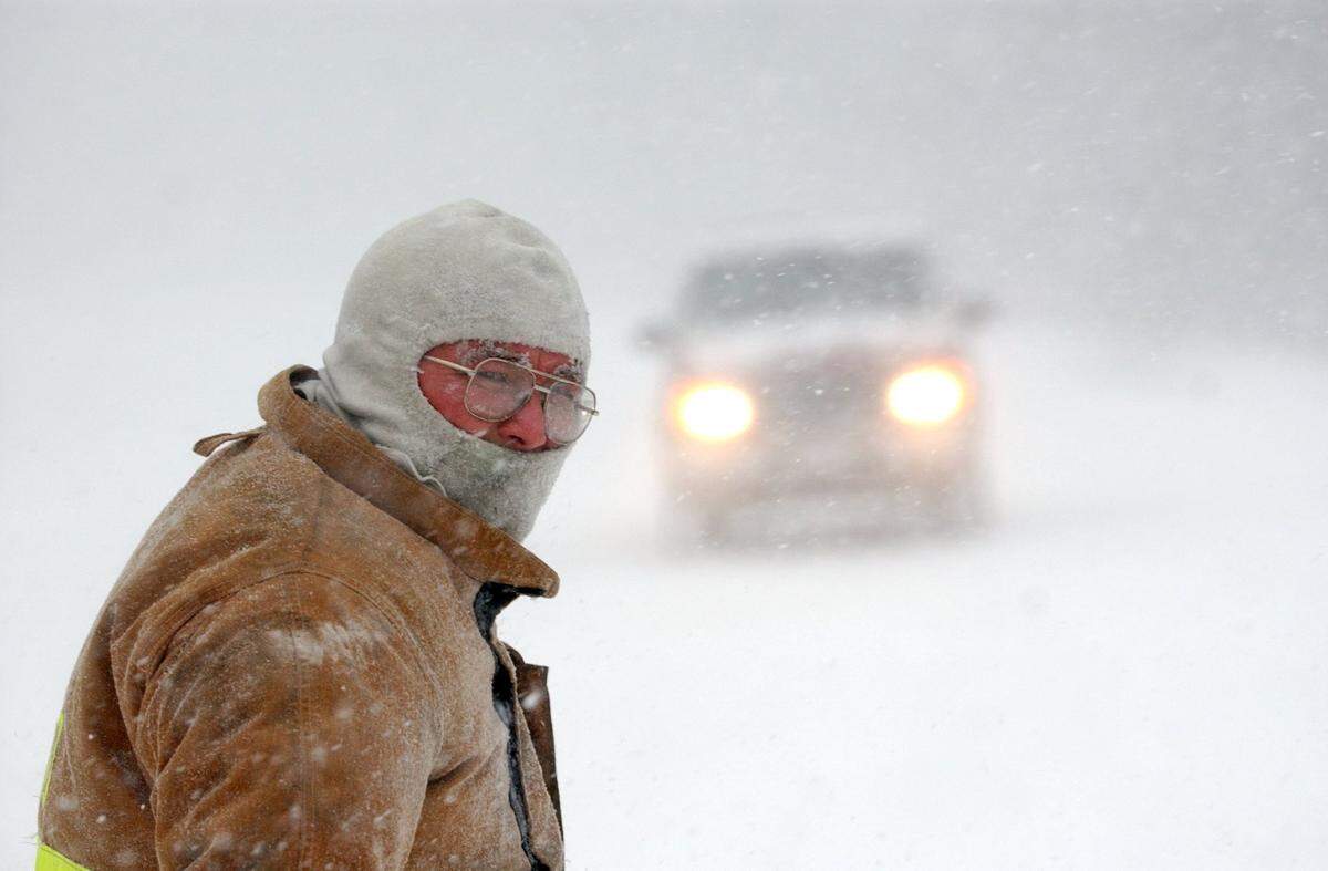 Wanchese fireman Mike Hekking directs traffic in blizzard conditions at the scene of a single vehicle accident in January 2002 as a winter storm moved across the Outer Banks of North Carolina. The snow combined with high winds made driving treacherous throughout Dare County.