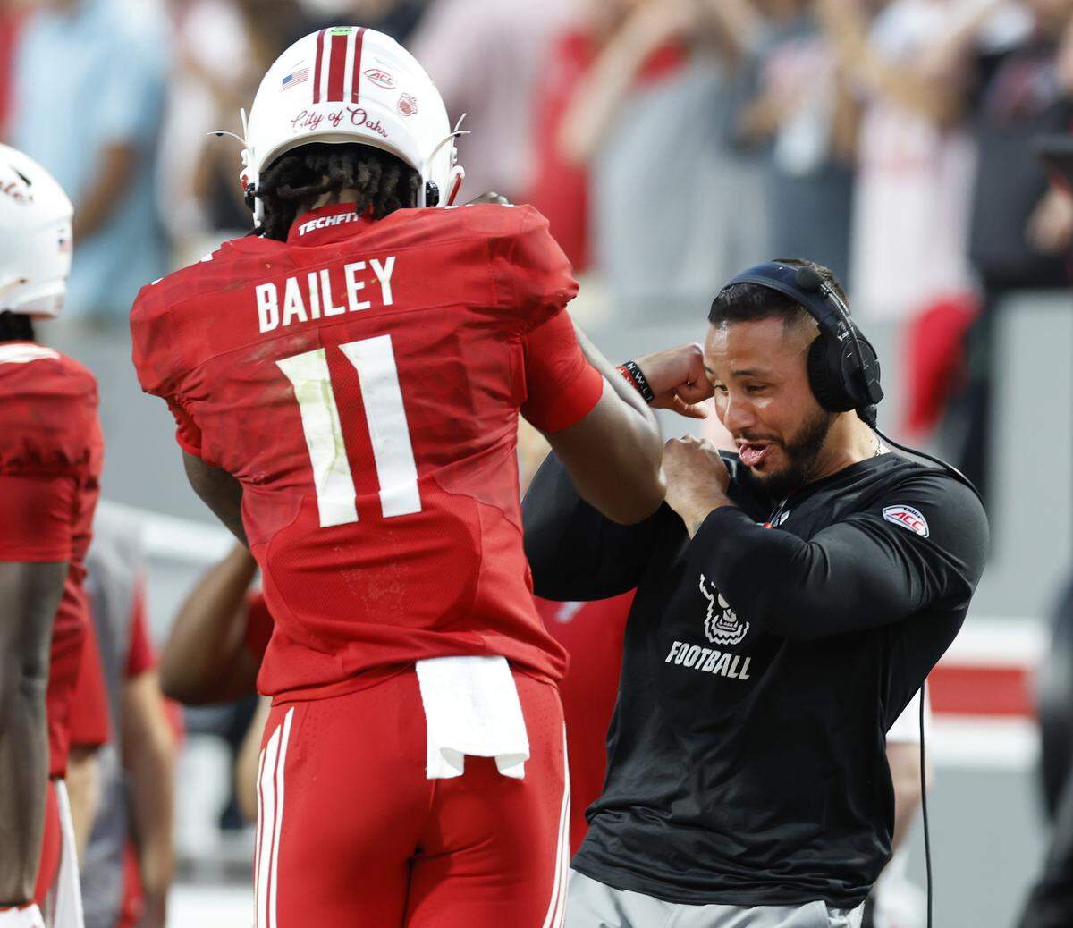 N.C. State linebacker coach Gavin Locklear celebrates with quarterback CJ Bailey (11) after Wesley Grimes scored on a 48-yard touchdown reception during the first half of N.C. State’s game against ECU on Aug. 28.