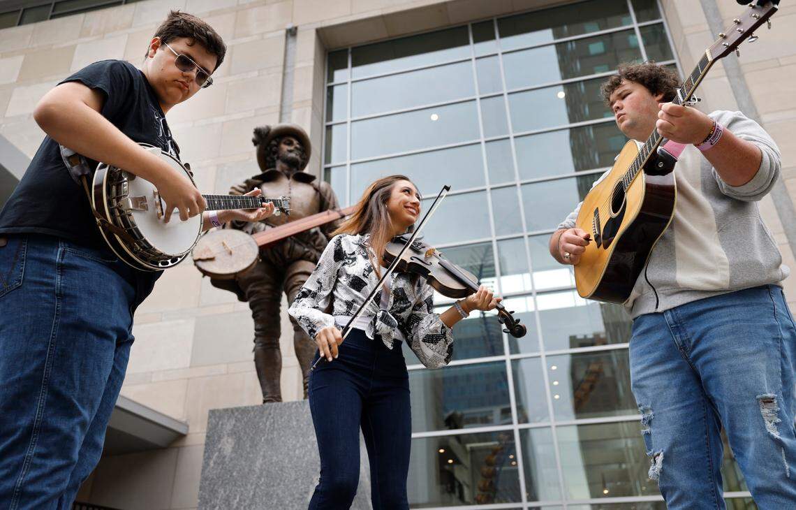 From left, Koltyn West on the banjo, Mary Parker on fiddle and Paul Grace on guitar play in front of the Sir Walter Raleigh statue outside the Raleigh Convention Center. The three are freshman at Bethel University in McKenzie, Tenn. and are in town for IBMA World of Bluegrass. IBMA Bluegrass Live! which includes free concerts on six stages and a street festival in and around Fayetteville Street occurs on Friday and Saturday. This year will be the last year the IBMA holds its event in Raleigh.