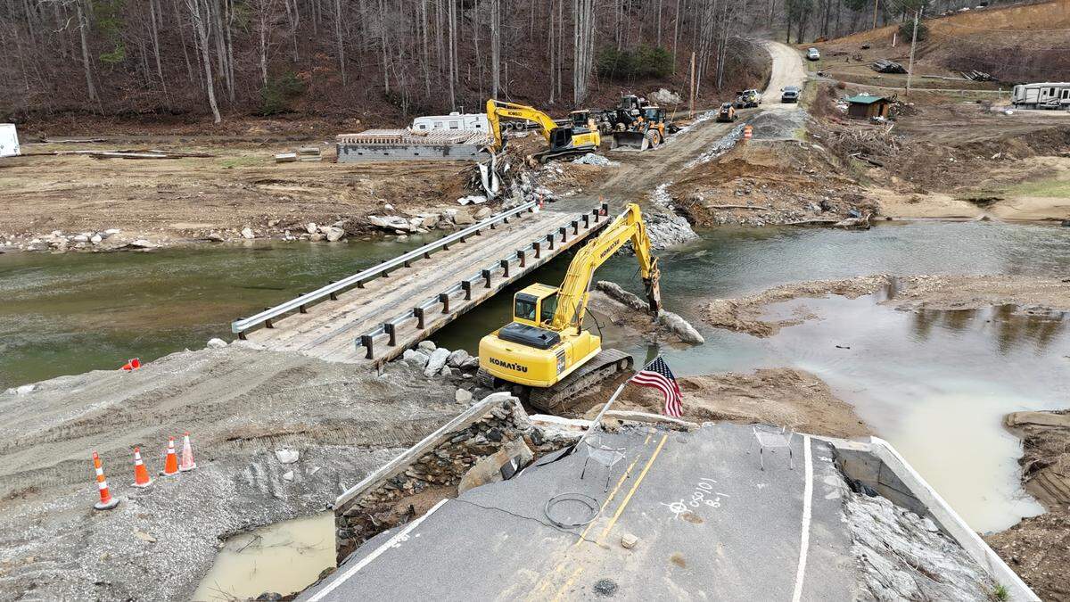 A temporary bridge made of retired railroad flatcars carries Elk River Road over the river in Avery County, after the remnants of Hurricane Helene washed out the permanent structure.